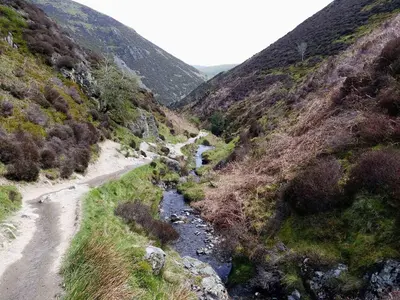 a dirt road in a mountain with a river at Home Farm House in Dorrington