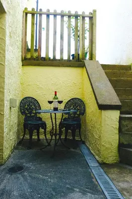 a table with two chairs and a bottle of wine at “Dragons Den” Centrally located Modern Apartment in Aberystwyth