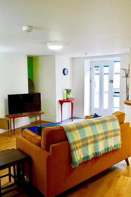 a living room with a couch and a television at “Dragons Den” Centrally located Modern Apartment in Aberystwyth
