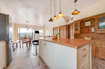 a kitchen with wooden cabinets and a counter top at 5 Bed in Llandovery oc-bow323 in Llangadog