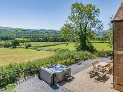 an outdoor patio with a barbecue and a grill and a table at 5 Bed in Llandovery oc-bow323 in Llangadog
