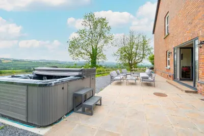 an outdoor patio with a grill and a table and chairs at 5 Bed in Llandovery oc-bow323 in Llangadog