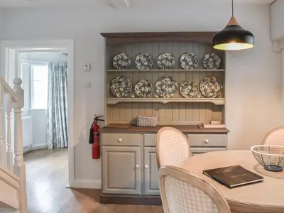 a kitchen with a table and plates on a shelf at Crogen Gatehouse Lodge in Corwen