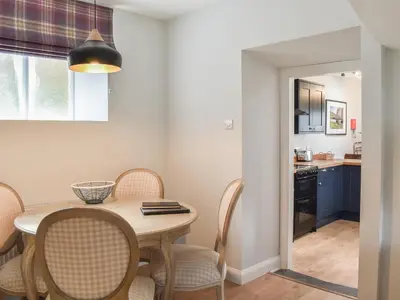 a kitchen and dining room with a table and chairs at Crogen Gatehouse Lodge in Corwen