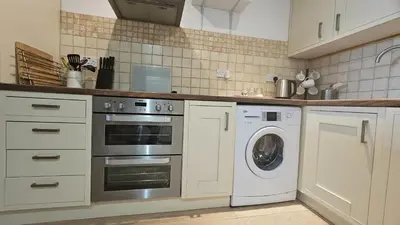 a kitchen with a washing machine and a washer at Talarfor Barmouth in Barmouth