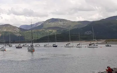 a bunch of boats are sitting in the water at Talarfor Barmouth in Barmouth