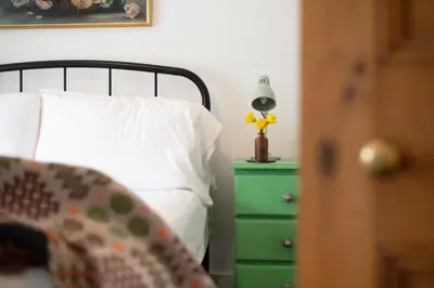 a bed with a white pillow and a green night stand at Cottage in heart of Dolgellau with parking in Dolgellau