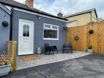 a blue house with two chairs and a white door at Westend Holiday Let 4 Brecon in Brecon