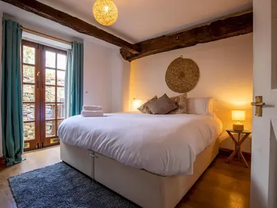 a bedroom with a large white bed and a window at Quaint 1 bedroom cottage in Church Stretton - Pass the Keys in Church Stretton