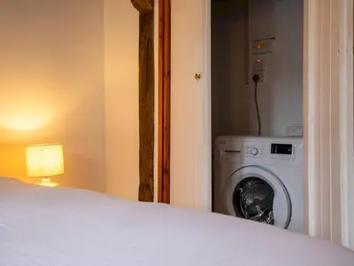 a bedroom with a bed and a washing machine at Quaint 1 bedroom cottage in Church Stretton - Pass the Keys in Church Stretton