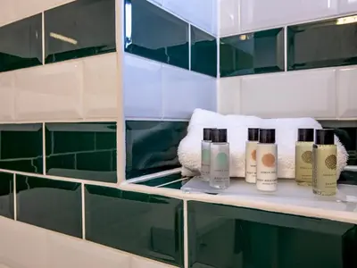 a shelf with four bottles of lotion and towels at Quaint 1 bedroom cottage in Church Stretton - Pass the Keys in Church Stretton