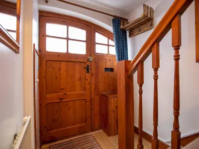 a wooden door in a hallway with stairs at Quaint 1 bedroom cottage in Church Stretton - Pass the Keys in Church Stretton