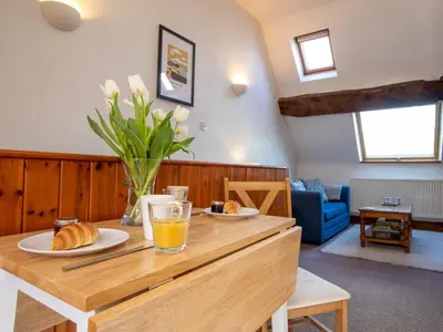 a living room with a wooden table with food on it at Quaint 1 bedroom cottage in Church Stretton - Pass the Keys in Church Stretton