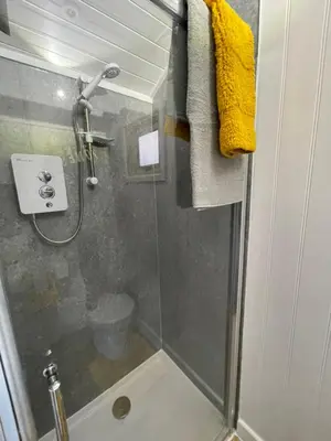 a bathroom with a shower with a glass door at Ty Olwyn Bach, Coity Bach in Brecon
