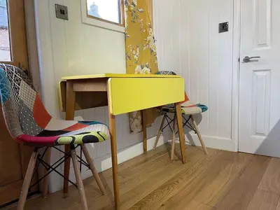 a yellow table and two chairs in a room at Ty Olwyn Bach, Coity Bach in Brecon