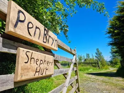 a wooden fence with a sign that reads perry shepherd hut at Pen Bryn Shepherd Hut in Hay-on-Wye