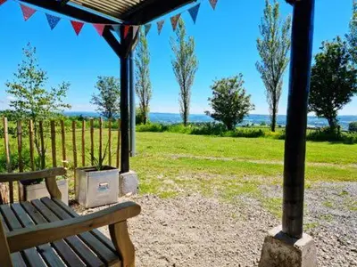 a wooden bench sitting under a gazebo in a park at Pen Bryn Shepherd Hut in Hay-on-Wye