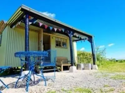 a blue picnic table in front of a house at Pen Bryn Shepherd Hut in Hay-on-Wye