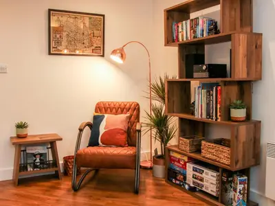 a living room with a chair and a book shelf at 6 The Engine Shed in Shrewsbury