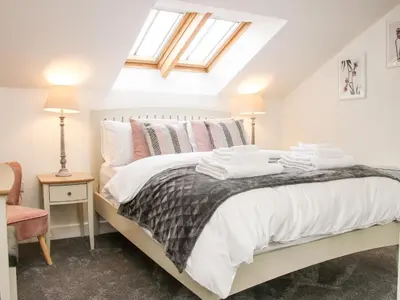 a bedroom with a bed with white sheets and pillows at 6 The Engine Shed in Shrewsbury