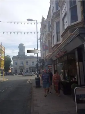 a group of people walking down a city street at Apartment One Aberystwyth Town Centre in Aberystwyth