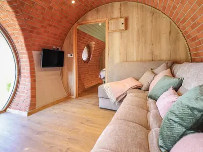 a couch in a room with a brick wall at Nant yr Esgair in Machynlleth