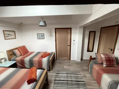 a hotel room with two beds and a couch at Converted barn, perfect MTB break, Coed y Brenin in Trawsfynydd