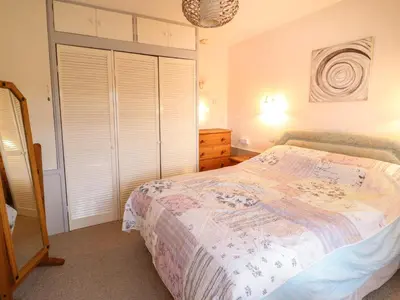 a bedroom with a bed with a dresser and a closet at Morlyn Guest House Apartment in Harlech