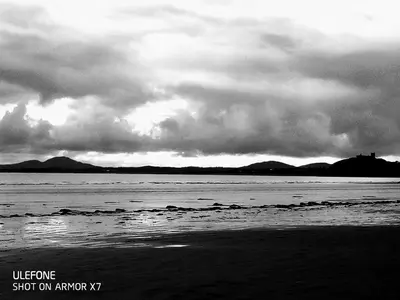 a black and white photo of a beach with clouds at Shifty Chicken Shack in Trawsfynydd