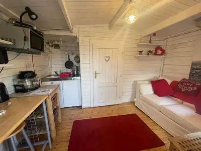 a living room with a couch and a kitchen at Ty Bach Twt, Coity Bach in Brecon
