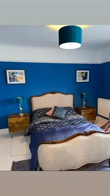 a blue bedroom with a bed and two end tables at Swn Y Don New Quay in New Quay