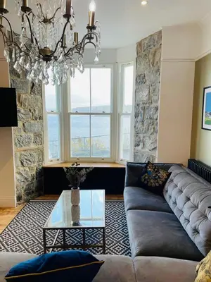 a living room with a couch and a glass table at Swn Y Don New Quay in New Quay