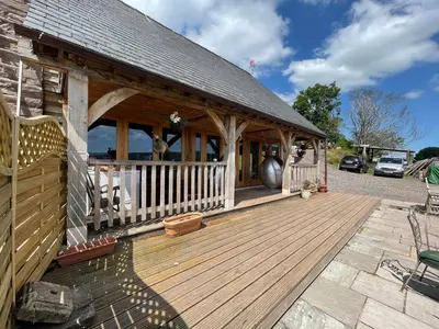 a house with a wooden deck with a building at Ty Nofio, Coity Bach in Brecon