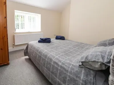 a bedroom with a bed with blue towels on it at Cae Iocyn in Wrexham