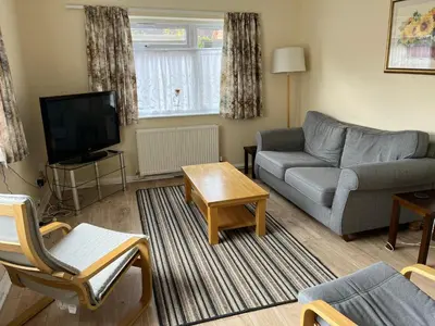 a living room with a couch and a tv at Large Ground floor apartment in the heart of Church Stretton with free parking in Church Stretton