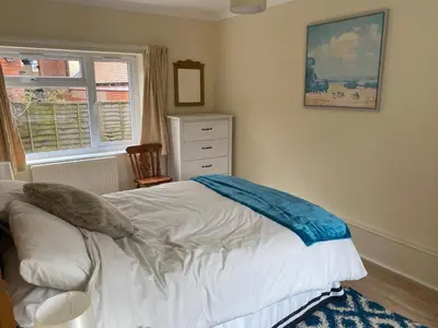 a bedroom with a bed and a dresser and a window at Large Ground floor apartment in the heart of Church Stretton with free parking in Church Stretton