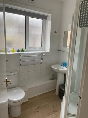 a bathroom with a toilet and a sink and a window at Large Ground floor apartment in the heart of Church Stretton with free parking in Church Stretton