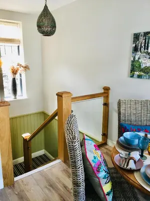 a living room with a table and a chair at The Art Attic a Stylish Boutique Apartment in Builth Wells