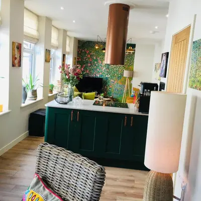 a kitchen with green cabinets and a sink at The Art Attic a Stylish Boutique Apartment in Builth Wells