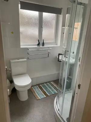 a bathroom with a toilet and a glass shower at Spacious first floor apartment in the centre of Church Stretton with free parking in Church Stretton