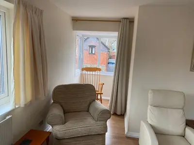 a living room with a chair and a window at Spacious first floor apartment in the centre of Church Stretton with free parking in Church Stretton