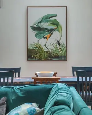 a living room with a green couch and a picture of a bird at The Old Fire Station Ludlow in Ludlow