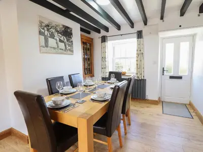 a dining room with a wooden table and chairs at Tan Y Capel in Llanbrynmair