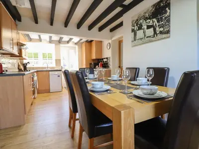 a dining room with a wooden table and black chairs at Tan Y Capel in Llanbrynmair