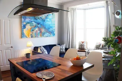 a living room with a dining room table with a bowl of fruit on it at Seaside Apartment in Aberystwyth
