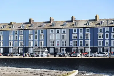 a large blue building with cars parked in front of it at Seaside Apartment in Aberystwyth