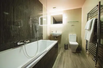 a bathroom with a tub and a toilet and a sink at RHUBARB at Drapers Hall in Shrewsbury
