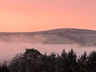 a view of a foggy valley with a mountain in the background at Beaconsview B&B in Brecon