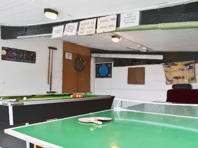 a ping pong table in a room with a pool table at Swallow Cottage in Llanfair Caereinion