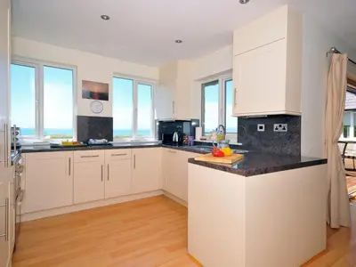 a kitchen with white cabinets and a counter top at Tir Gafr in Harlech